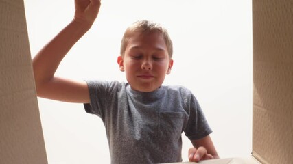 Frustrated, disappointed teenage boy open cardbox and looking inside of package. Kid opens or unpacking present gift box. Sad, unsatisfied, angry, unhappy emotions. 4k video