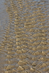 abstract effect of water movement on a sandy bottom with sunny reflections