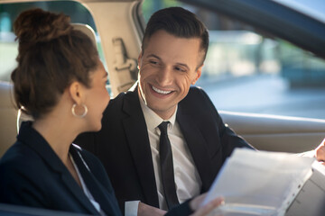 Man and woman conducting business negotiations in a car