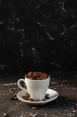coffee beans in a small white cup. sprinkled coffee beans