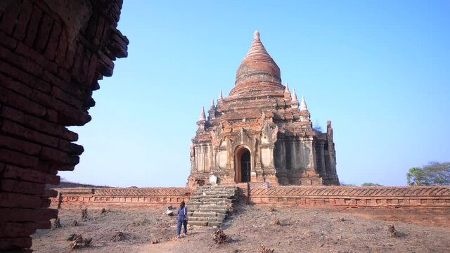 Woman walking towards an ancient temple in Bagan, Myanmar
