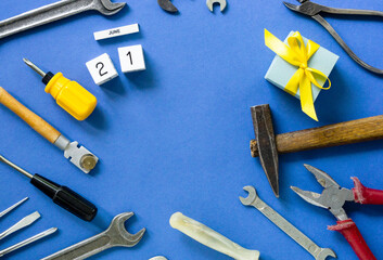 Flat lay for father's day with tools and gift box on a blue background