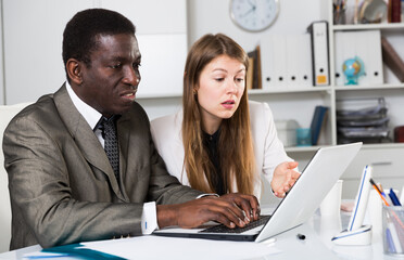 Man and woman managers  with laptop working and discussing