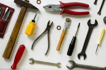 Layout of repair and construction tools on a white wooden background