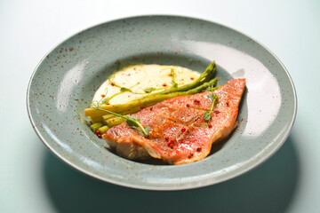 Grilled meat steak with sauce and spices served on a plate over bright pastel blue mint background.