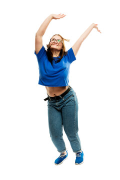 Laughing Fat Young Girl In Glasses And Jeans Emotionally Jumps Up. Energy And Movement. Isolated On A White Background. Vertical.