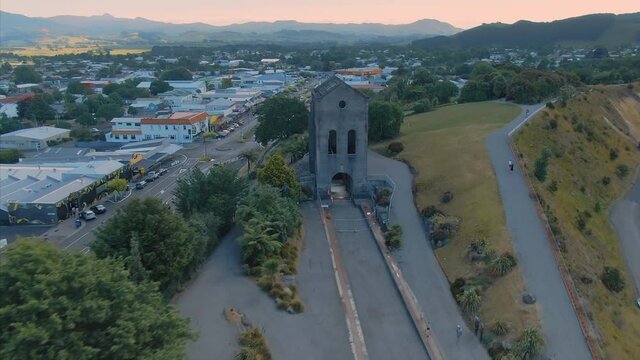 Aerial: Cornish pumphouse at the Martha Open Pit Gold Mine and the town of Waihi, New Zealand