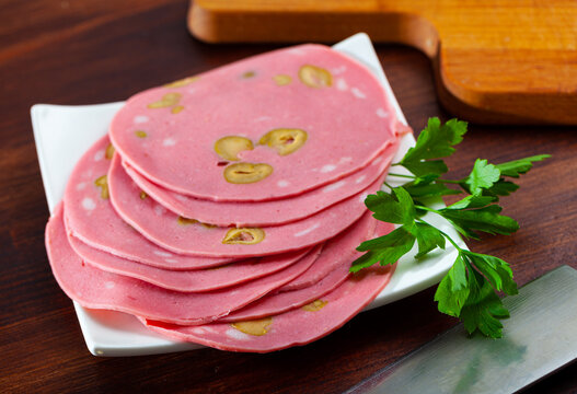 Close-up of sliced mortadela sausage with olives