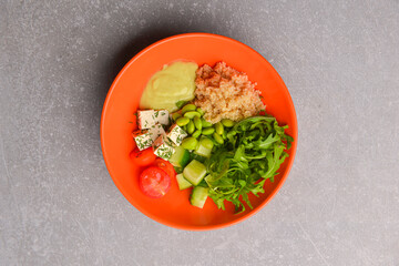 Fresh and organic vegetable salad with raw veggies - tomatoes, cucumbers, seeds and feta cheese.