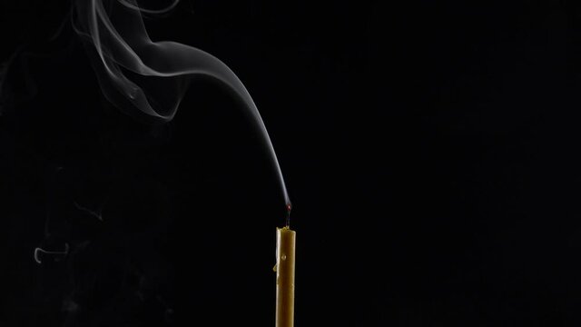 Shining candle flame in a dark room. Blowing out the candles. Beautiful gray smoke rises.