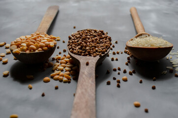 rice, buckwheat, peas in wooden spoons are on the table