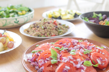 Fresh salad with garnishing and meal on table