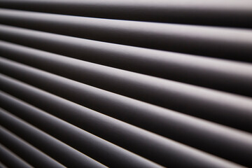 Obraz premium contrasty abstract close up filled frame background wallpaper shot of grey window blinds with rays of light shining through and leaving hard black shadows that create beautiful diagonal lines