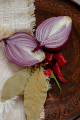 red sweet onion on a black background with hot pepper and spices