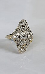Art Deco diamond and yellow gold dress ring against a white background.