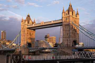 Tower Bridge in London bathed in the warm glow of a golden summer sunrise.