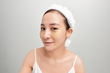 close-up of beautiful young Asian woman with bath towel on head covering her head on white background.