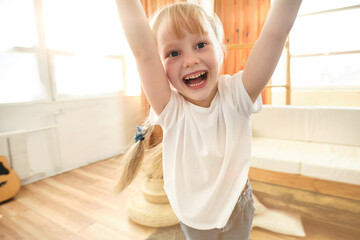 Portret of happy child is playing with parent at home. Father is spinning with daughter.