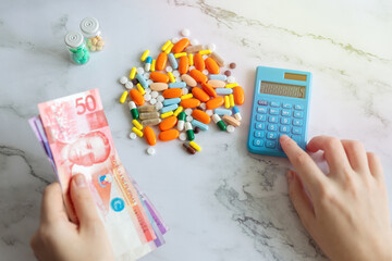 Philippine peso money, calculator and medicine pills. Health care cost in the Philippines concept