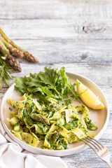 Fresh homemade tagliatelle with spinach and asparagus. pasta with cream sauce and vegetables.