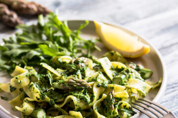 Fresh homemade tagliatelle with spinach and asparagus. pasta with cream sauce and vegetables.