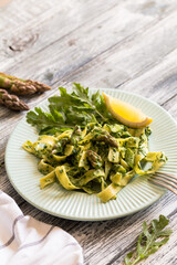 Fresh homemade tagliatelle with spinach and asparagus. pasta with cream sauce and vegetables.