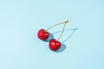 Obraz na płótnie Canvas Ripe cherry berries on a blue background. Flat lay, top view.
