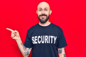 Young handsome man wearing security t shirt smiling happy pointing with hand and finger to the side