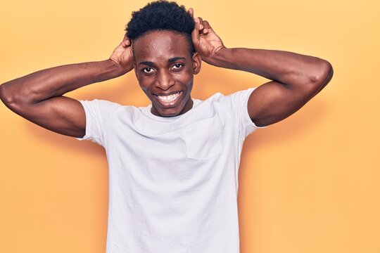 Young african american man wearing casual clothes posing funny and crazy with fingers on head as bunny ears, smiling cheerful