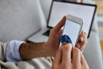 Close-up of a man cleaning his smart phone.
