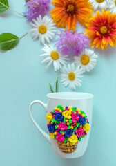 The original mug with decorative figurines made with their own hands. A lovely birthday present. Figures on the cup are fashioned hand made from colored clay. Fresh flowers background.