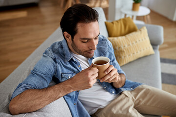 Relaxed man enjoying in cup of tea at home.