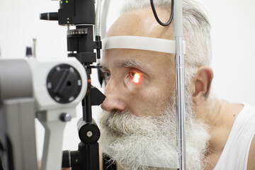 Senior patient checking vision with special eye equipment
