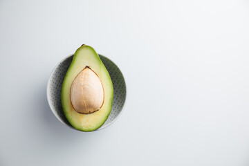 Avocado on a plate and on a white background. Minimum concept