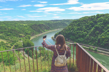 Beautiful mountain landscape with young woman enjoying wanderfull view, tacking a good selfie