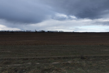Gloomy steppe landscape. Beautiful cloudy sky over the field.