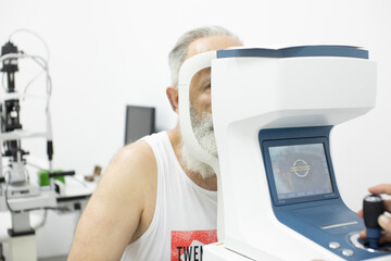 Senior patient checking vision with special eye equipment