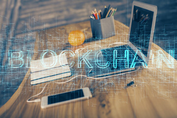 Double exposure of blockchain and crypto economy theme hologram and table with computer background. Concept of bitcoin cryptocurrency.