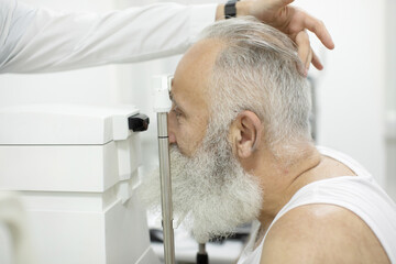 Obraz na płótnie Canvas Senior patient checking vision with special eye equipment