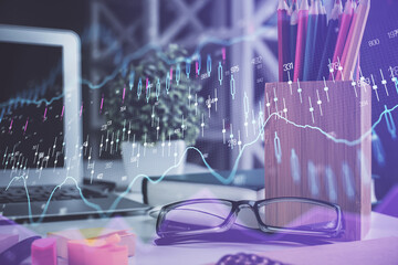 Financial chart hologram with glasses on the table background. Concept of business. Double exposure.