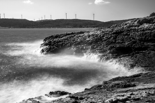 Dramatic image with rocks and sea long exposure and black and white.