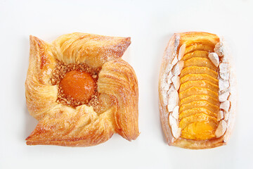 Danish puff with apricot jam or Danish rolls with peach on a white background. An isolated object. Copy of the space. Top view.