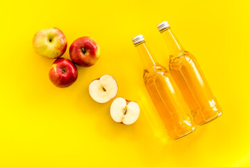 Apple cider vinegar bottle on yellow background top view