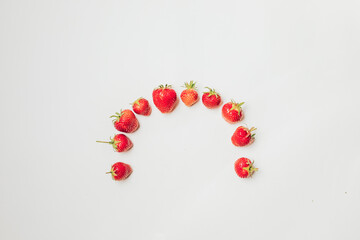 strawberries arranged in a semicircle on a white background with a lot of space