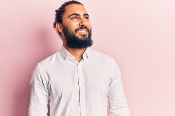 Obraz premium Young arab man wearing casual clothes looking away to side with smile on face, natural expression. laughing confident.