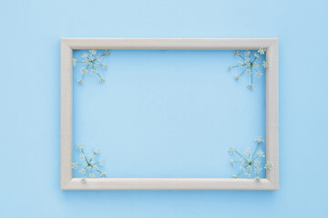 Spring, floral background. Frame with fresh white flowers on a blue background. Flat lay, space for text. View from above. Spring concept. Mother's Day, Women's Day.