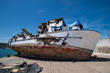 An old sunken boat lies on a pier