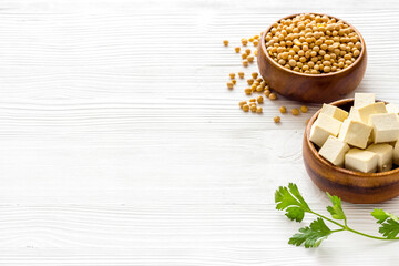 Tofu cubes with soybeans on white kitchen table copy space