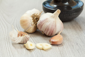 Raw garlic bulbs on a gray wooden background.