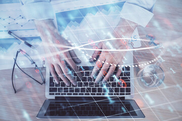 Double exposure of market chart with man working on computer on background. Concept of financial analysis.